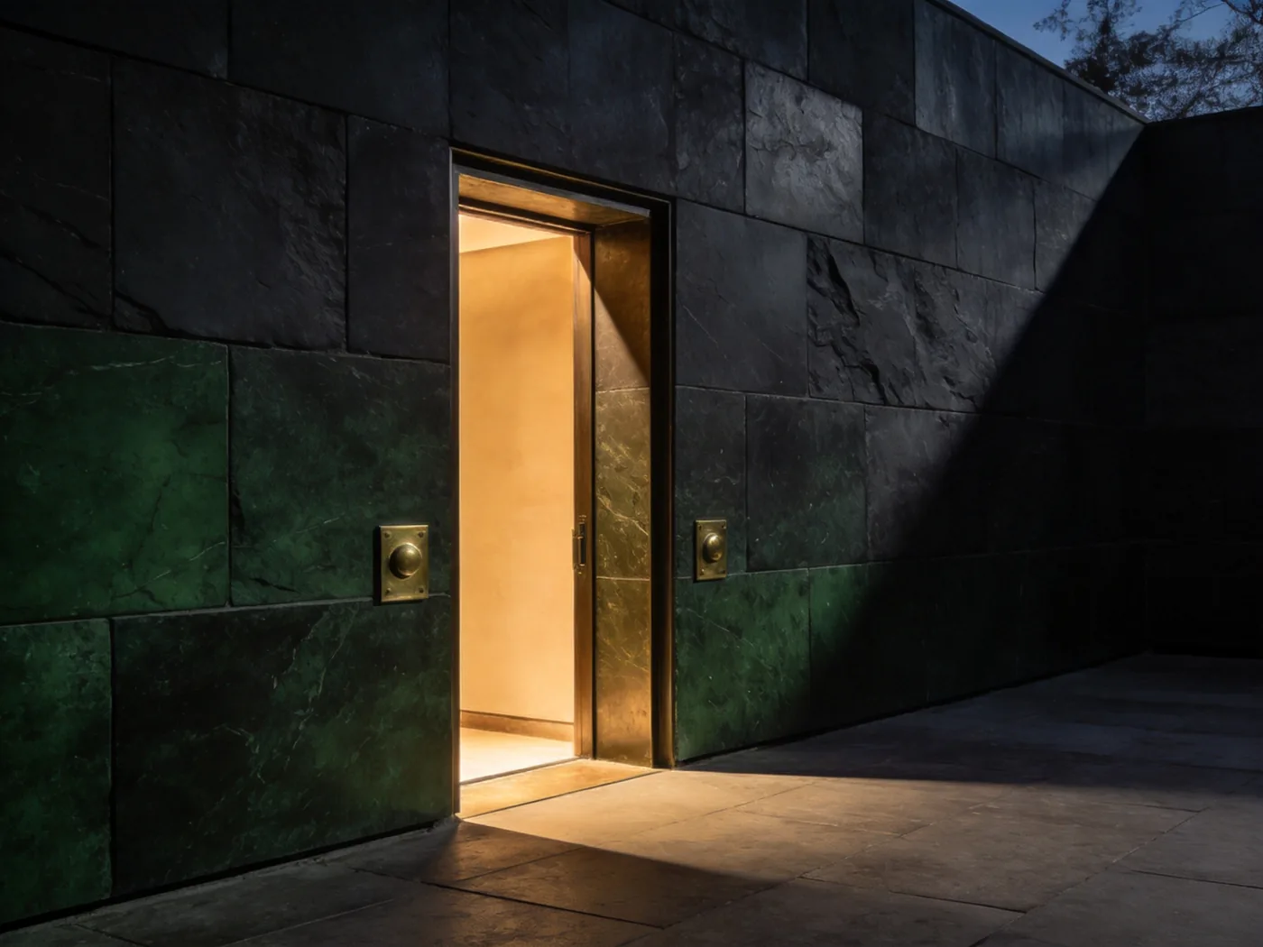 A dark stone facade with one deep-set doorway lit from within
